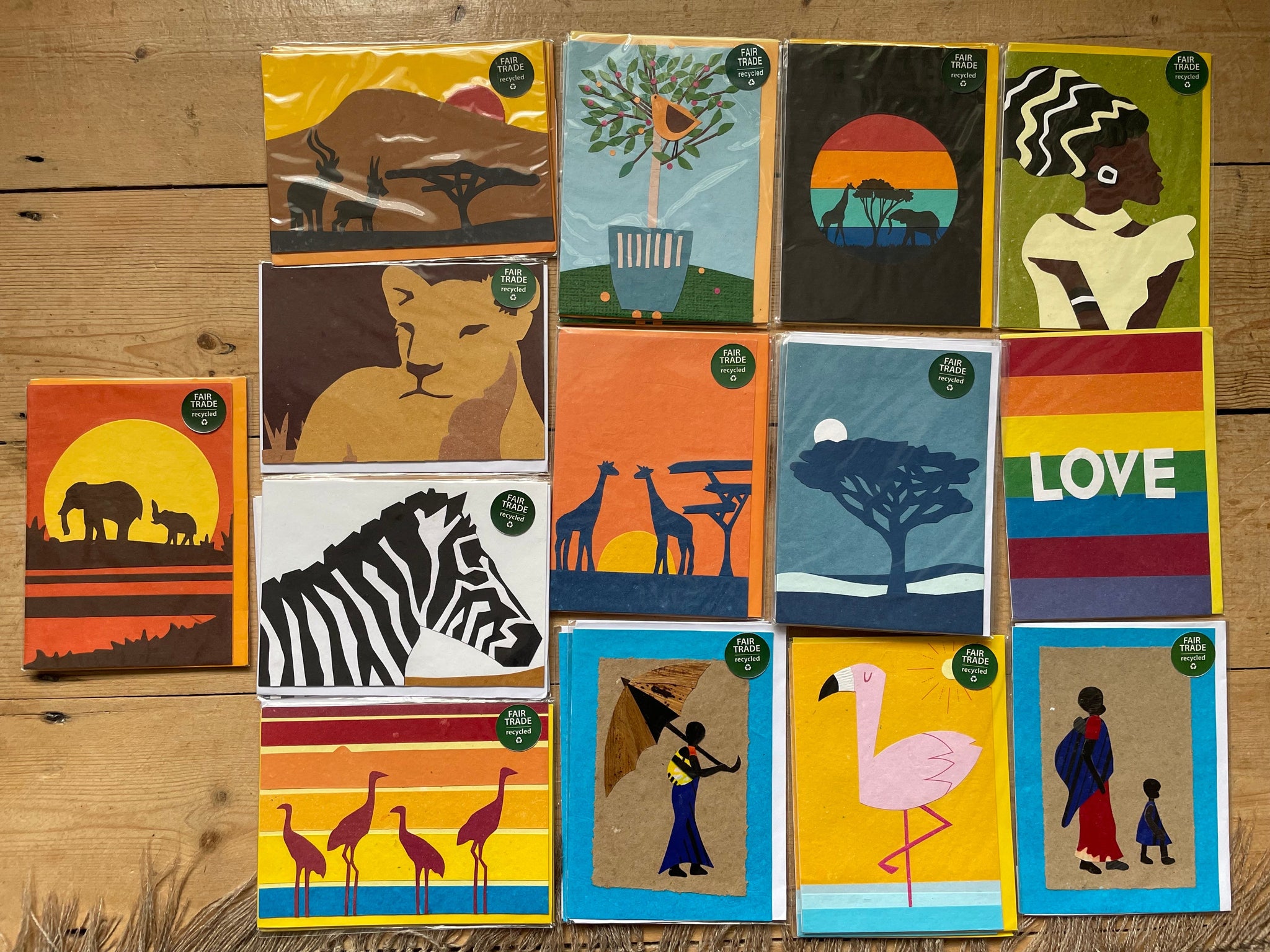 Handmade greeting card featuring a landscape, animals and women in silhoettes design in warm, earthy tones, created from upcycled paper by women artisans in Rwanda